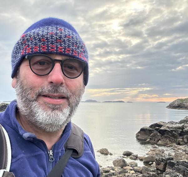 Neil Barker in front of some coastal scenery