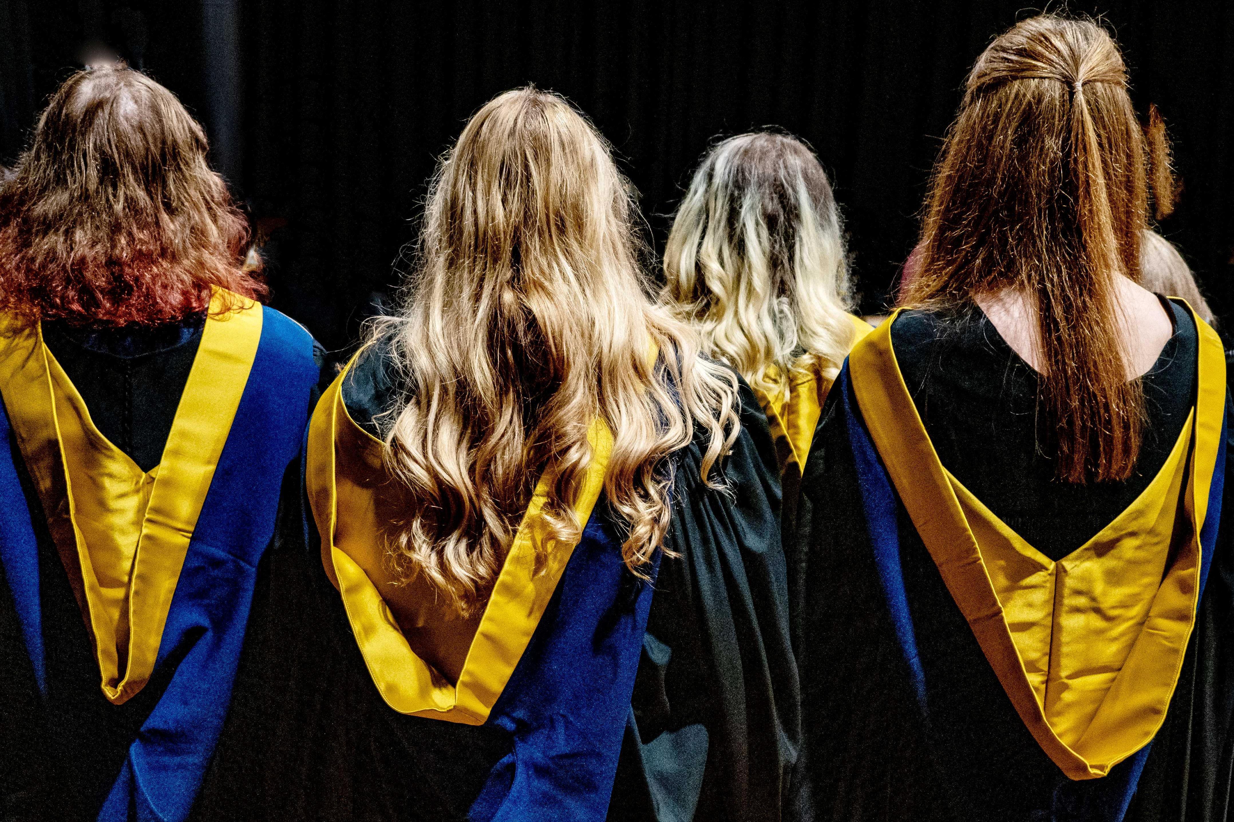 a group of graduates shot from behind wearing their gowns and hoods at the graduation ceremony in Fort William 2023