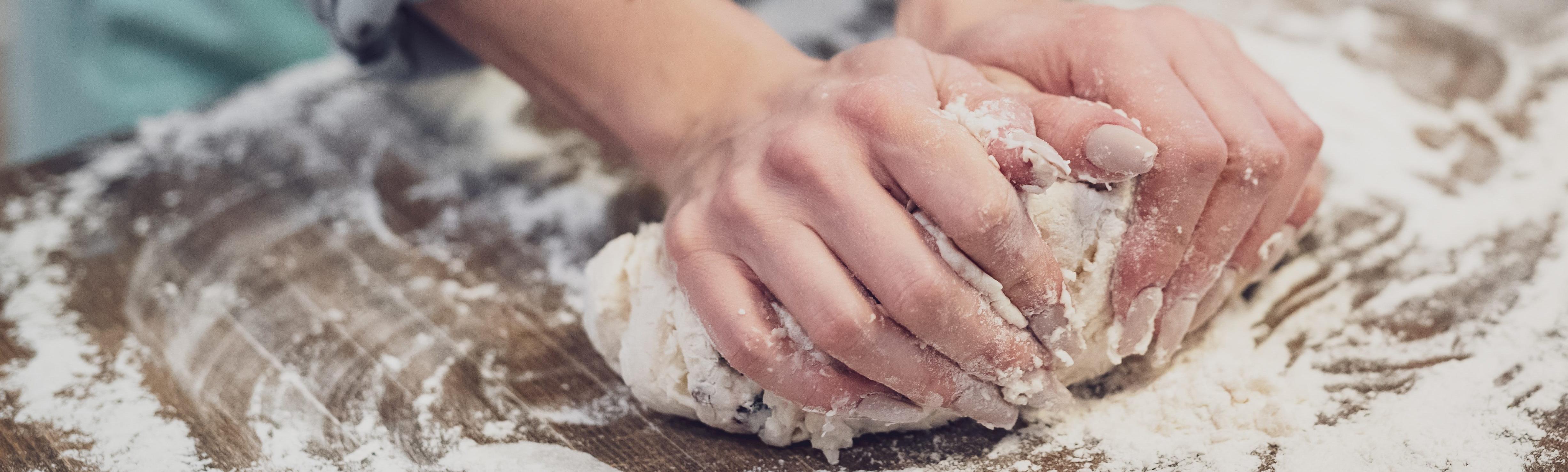 person kneading dough