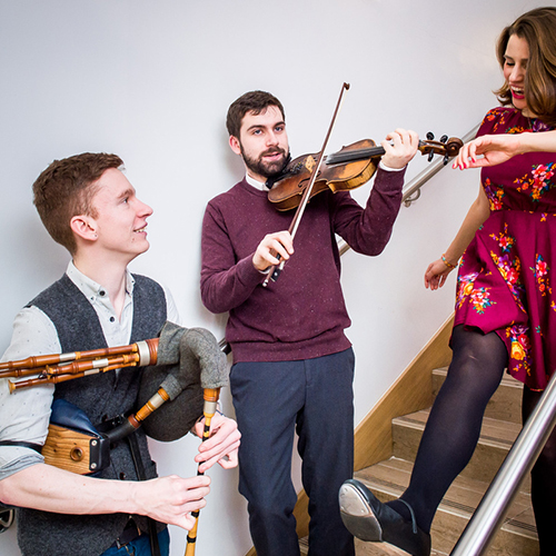 Two musicians playing instruments and a person dancing