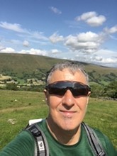 Steve Button wearing sunglasses taking a selfie on a hill