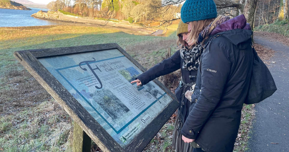 Two walkers looking at COAST route stop